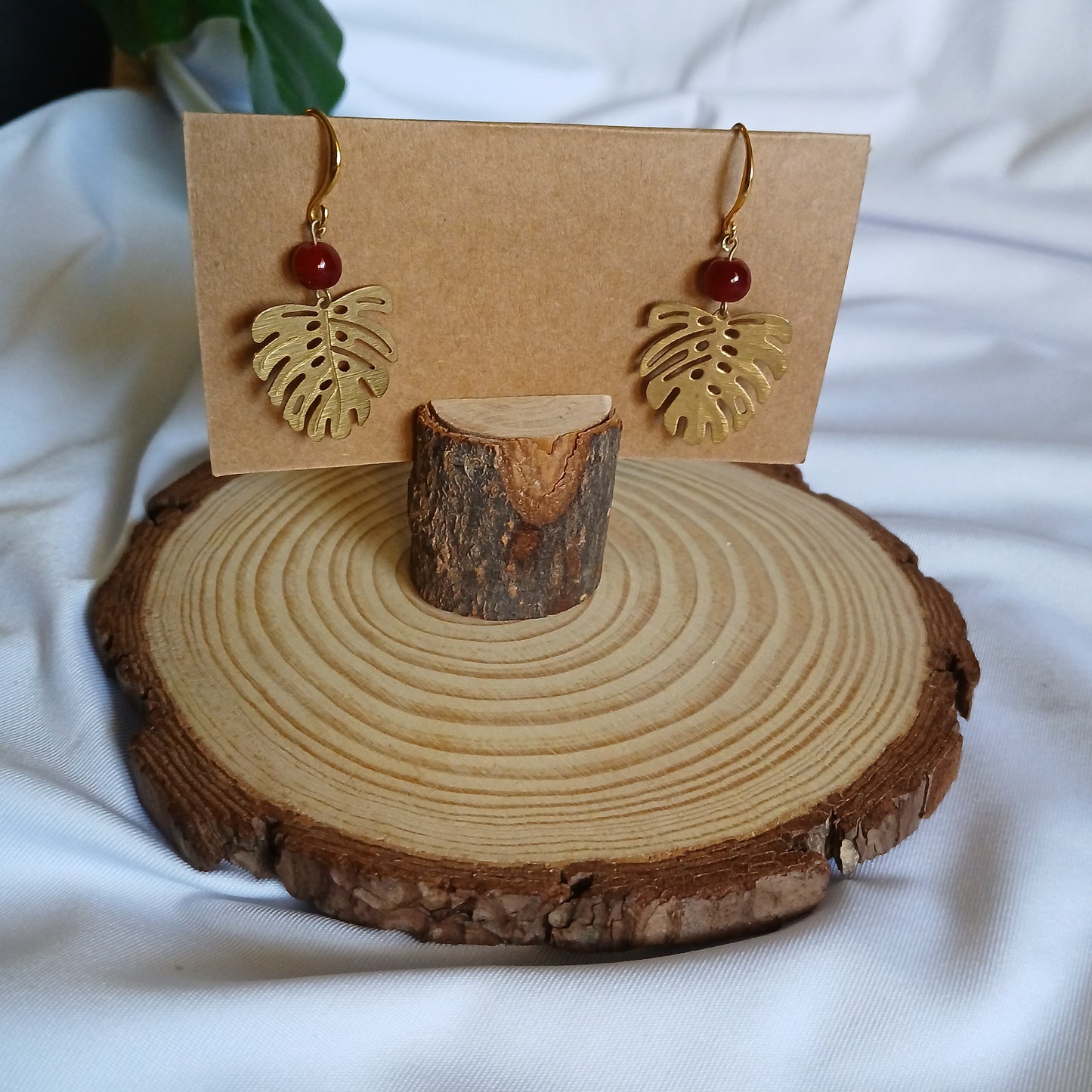 Gold monstera earrings with round fire agate balls